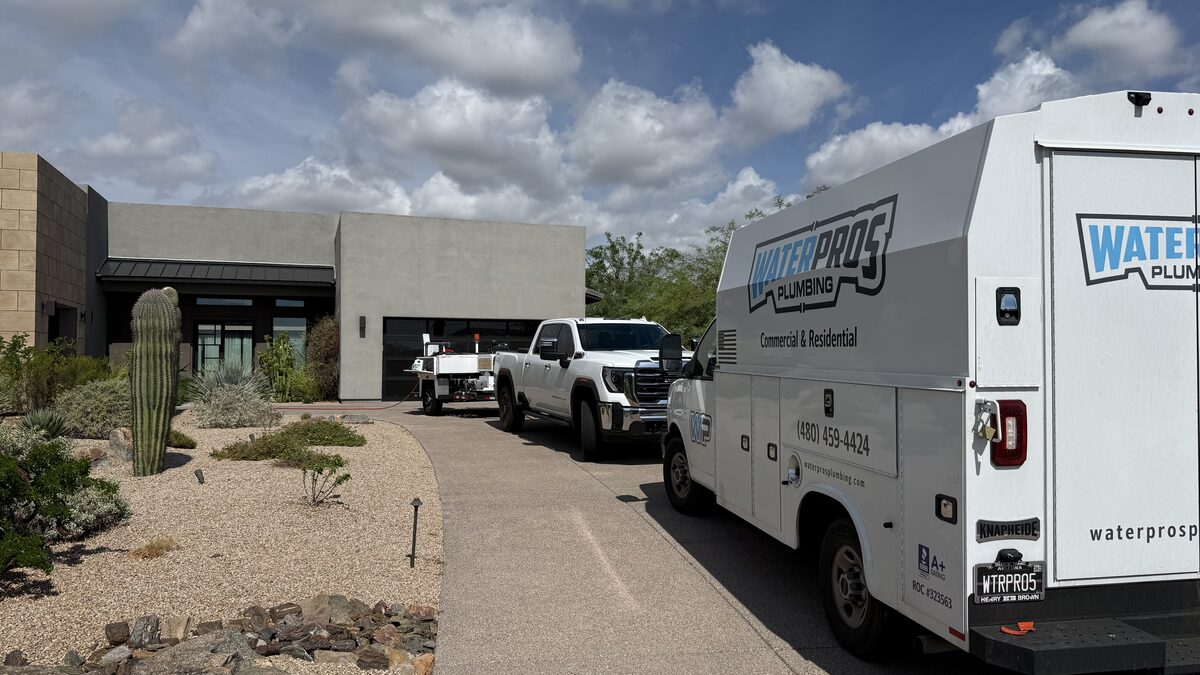 Water Pros Plumbing trucks parked outside a luxury Troon home in Scottsdale AZ before a kitchen drain cleaning job